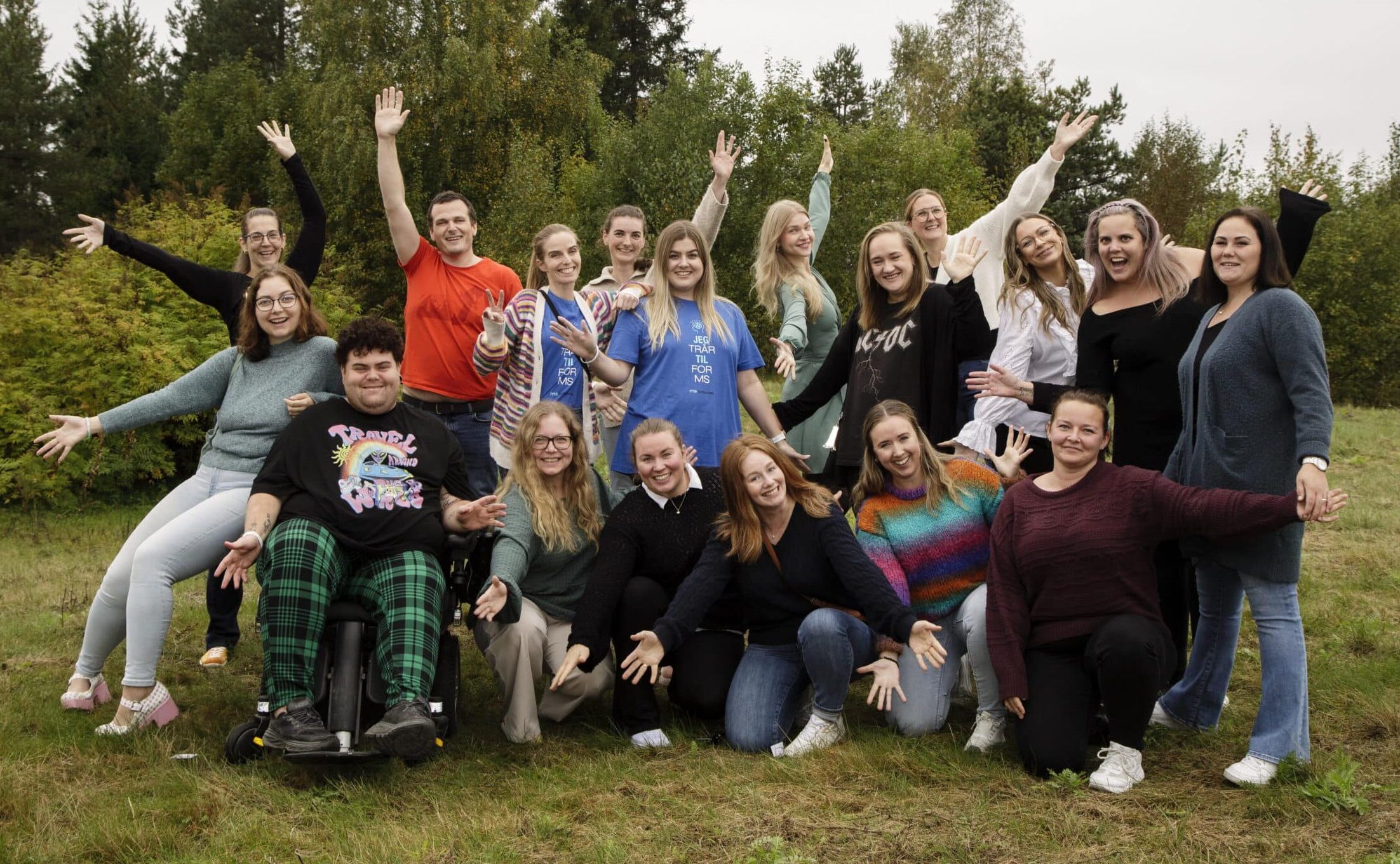 Bildet som viser en gjeng med mennesker som står oppstilt og veiver med armene. Menneskene er unge med MS. Bildet kan brukes til å illustrere samhold og engasjement.