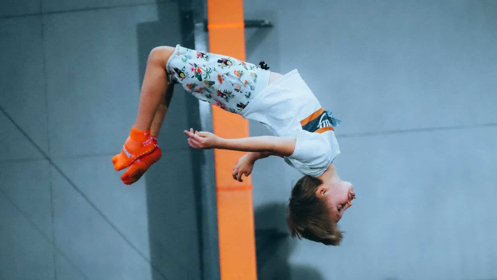 Bilde som viser en gutt som tar salto på en trampoline.