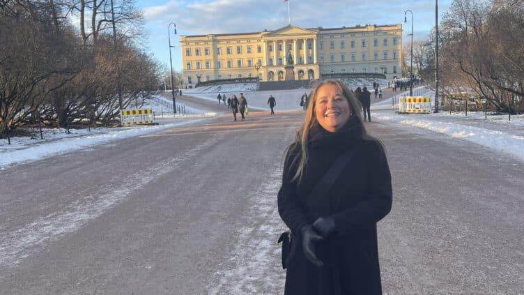 Bilde av Hege Tange, likeperson i MS-forbundet. Hun står foran slottet i Oslo.